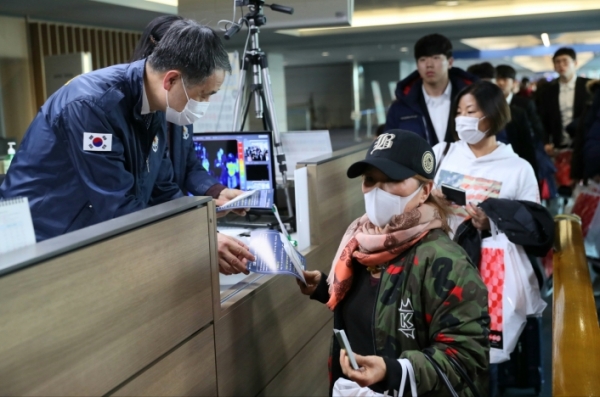 박능후 보건복지부 장관이 23일 인천국제공항에서 우한 폐렴 관련 안내문을 여행객에 전달하고 있다. [제공=보건복지부]