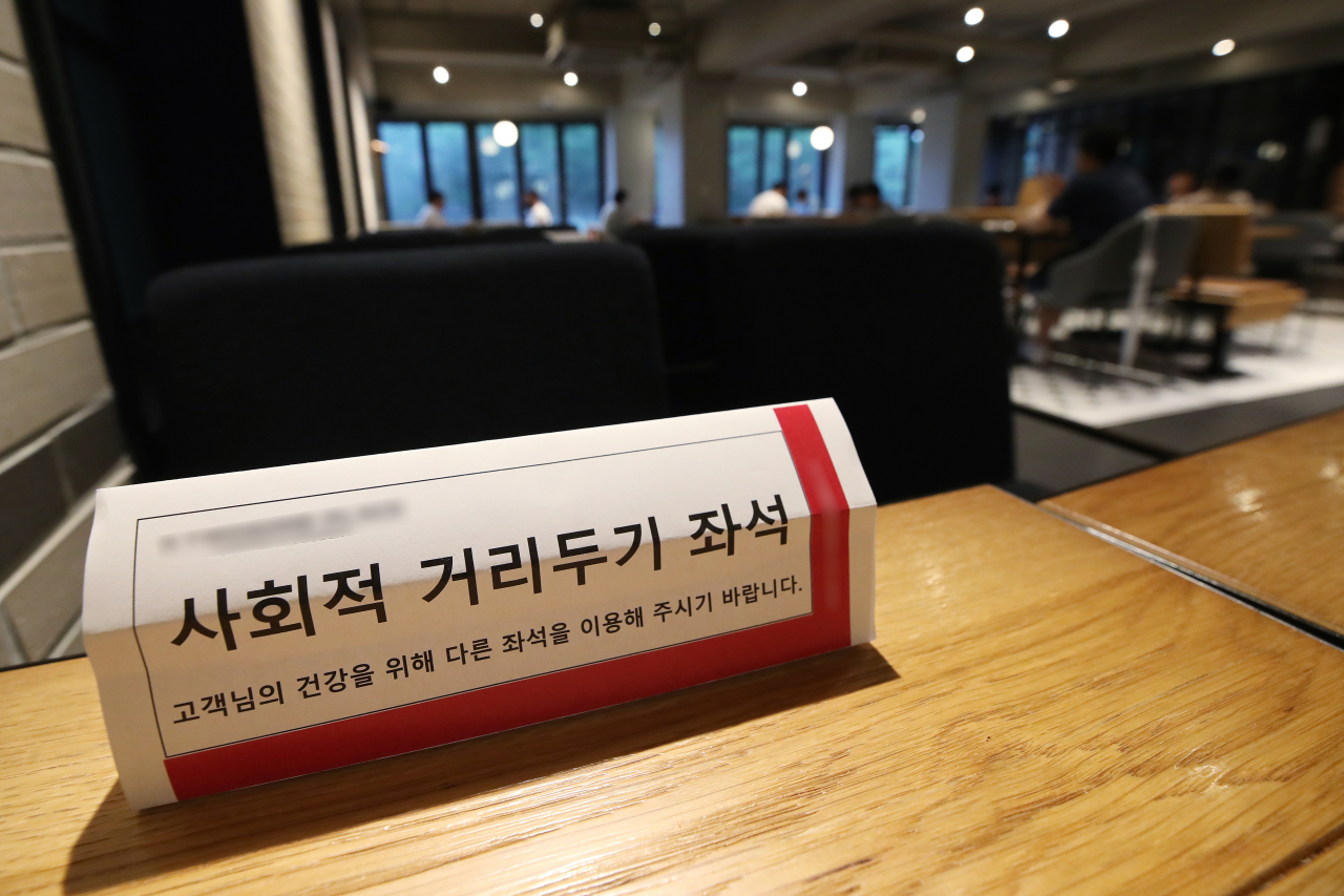 사회적 거리두기를 강화한 가운데 지난 10일 서울의 한 카페에 거리두기 관련 안내문이 부착되어 있다. [출처=연합뉴스]
